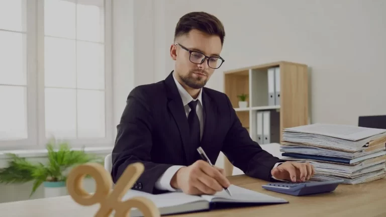 Henkilö toimistossa vertailee ja laskee korkoja sekä tarkastelee lainan kuukausierän jakautumista lyhennykseen ja korkoon sekä niiden muutosta laina-aikana.
